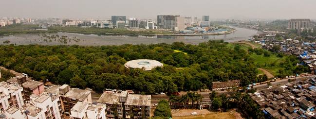 Rooftops of Dharavi the foreground, broken by the green cover of MNP along the Mithi River with modern-day architecture of BKC in the background